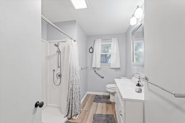 a bathroom with a sink a toilet and shower