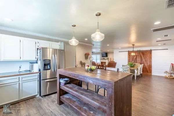 a kitchen with a refrigerator a sink and dishwasher with wooden floor