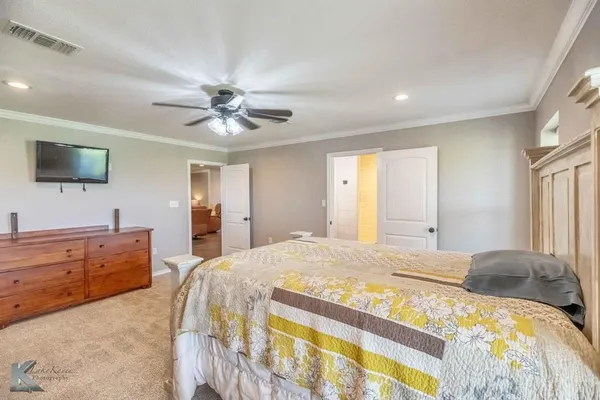 a spacious bedroom with a bed and a flat screen tv