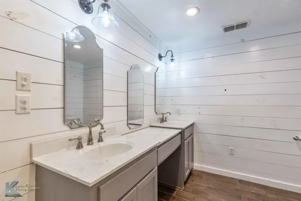 a bathroom with a sink shower and a mirror