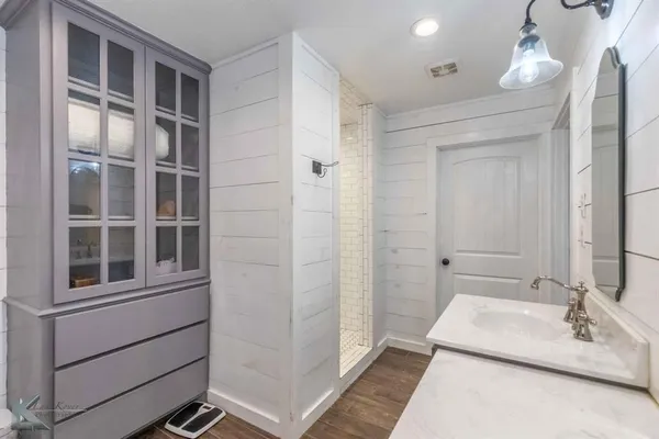 a bathroom with a double vanity sink a mirror and a shower