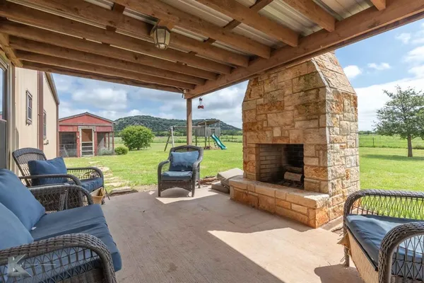 a outdoor space with patio the couches and a fireplace with the potted plants