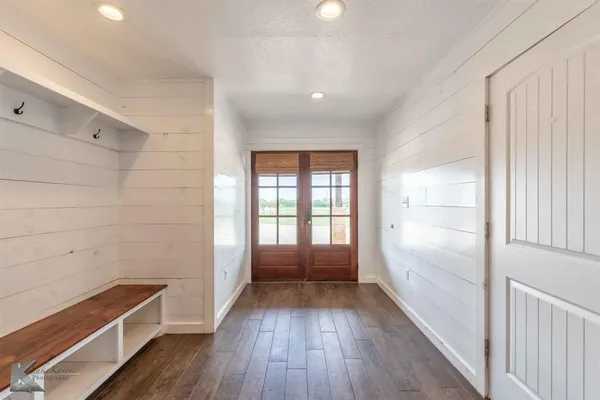 a view of hallway with wooden floor and cabinets