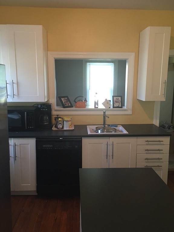 529 White Street Springfield, MA 01108 - Photo 3 of 16 a kitchen with granite countertop a sink stainless steel appliances wooden floor and cabinets
