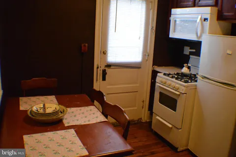 a kitchen with a stove and wooden floor