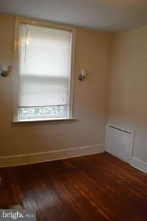 a view of a small space with wooden floor and a window