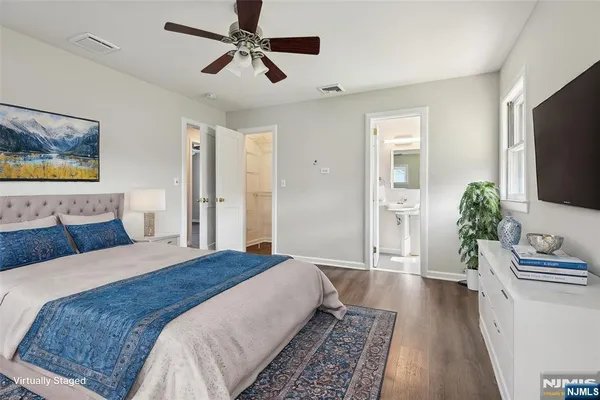 a spacious bedroom with a bed and a flat screen television