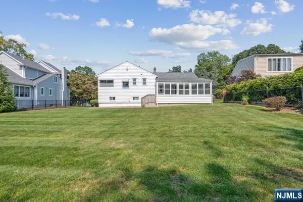 a view of a house with a big yard and large trees