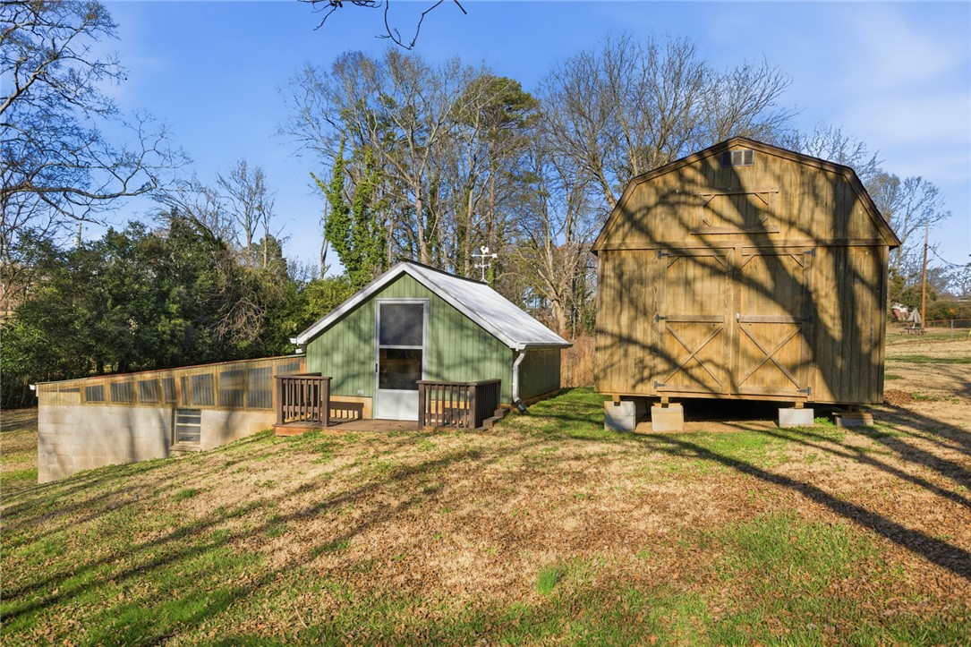 1005 Pinecroft Drive Anderson, SC 29621 - Photo 18 of 50 This expansive yard features two charming outbuildings, offering versatile space for hobbies or storage.