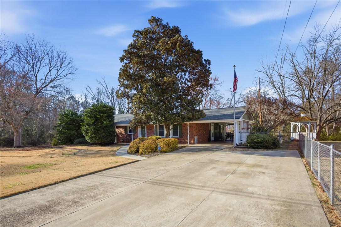 1005 Pinecroft Drive Anderson, SC 29621 - Photo 3 of 50 A classic brick ranch home awaits, featuring a spacious driveway and mature landscaping.