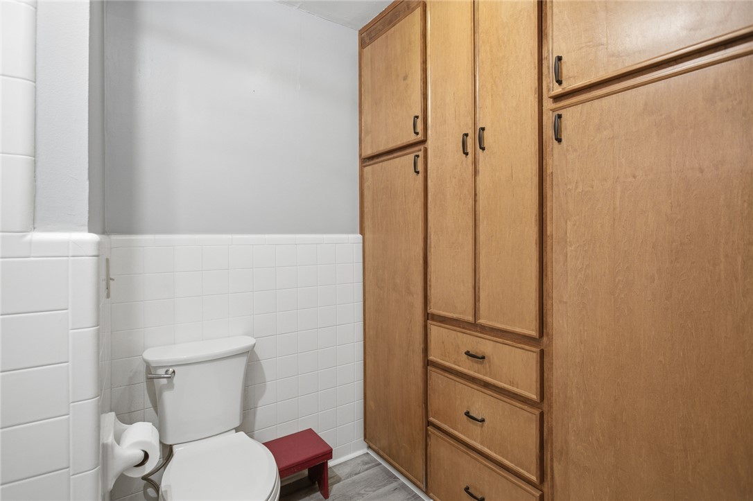 1005 Pinecroft Drive Anderson, SC 29621 - Photo 32 of 50 This bathroom features functional built-in storage solutions and a classic tiled wainscoting.