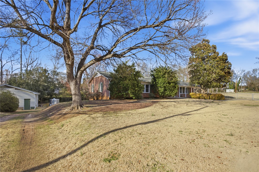 1005 Pinecroft Drive Anderson, SC 29621 - Photo 10 of 50 This charming home features a classic brick exterior and a vast, sun-drenched lawn.