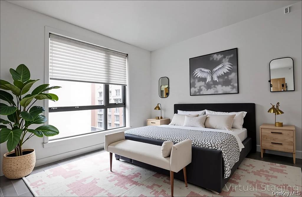 41-04 27th Street, Unit 8C Queens, NY 11101 - Photo 3 of 9 a spacious bedroom with a large bed and a potted plant