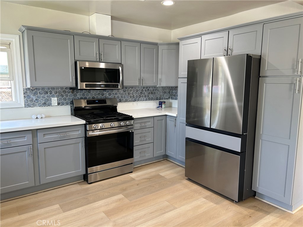 3375 Baltic Avenue Long Beach, CA 90810 - Photo 23 of 24 a kitchen with white cabinets and stainless steel appliances