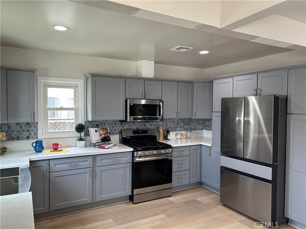 3375 Baltic Avenue Long Beach, CA 90810 - Photo 8 of 24 a kitchen with a refrigerator stove and microwave