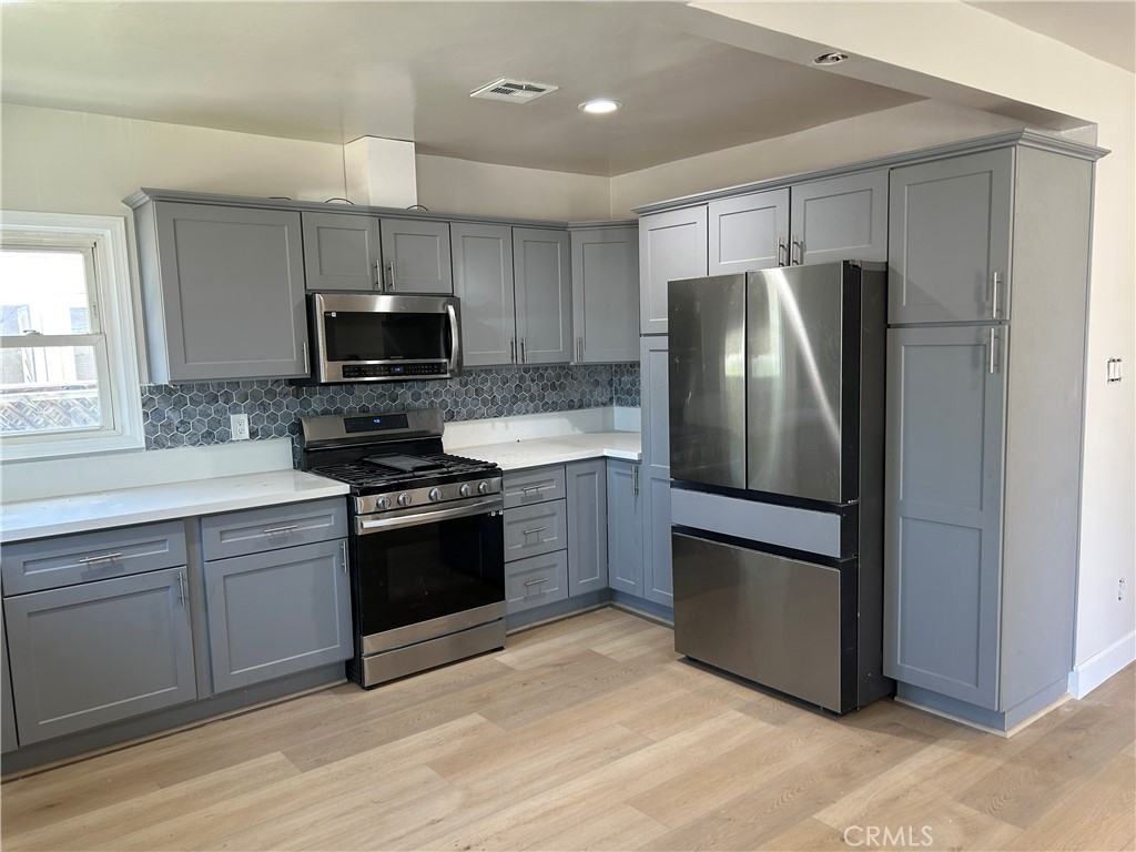 3375 Baltic Avenue Long Beach, CA 90810 - Photo 9 of 24 a kitchen with a refrigerator stove and microwave