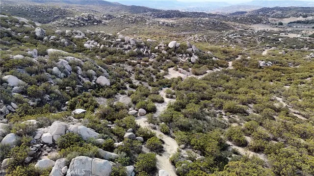 an aerial view of a houses with a lush green hillside