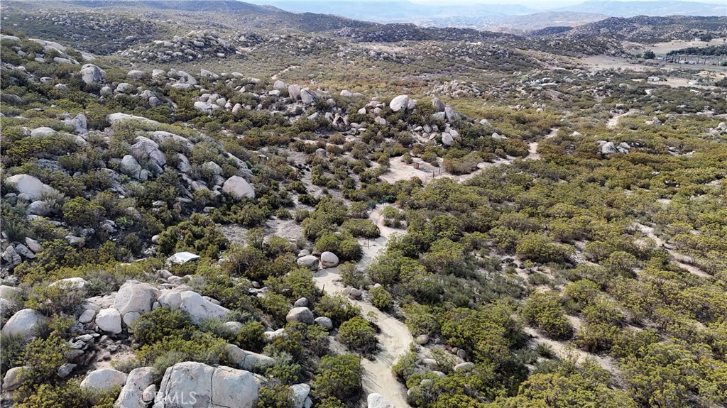 an aerial view of a houses with a lush green hillside