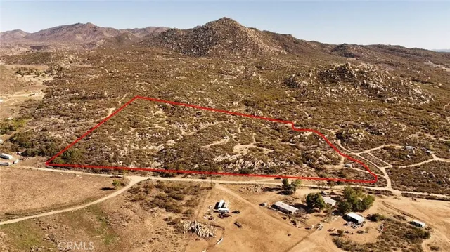 a view of a dry yard with wooden fence