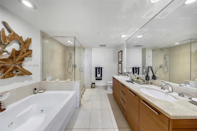 a large bathroom with a tub double sink and mirror