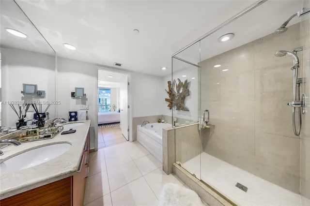 a large bathroom with a tub sink shower and mirror
