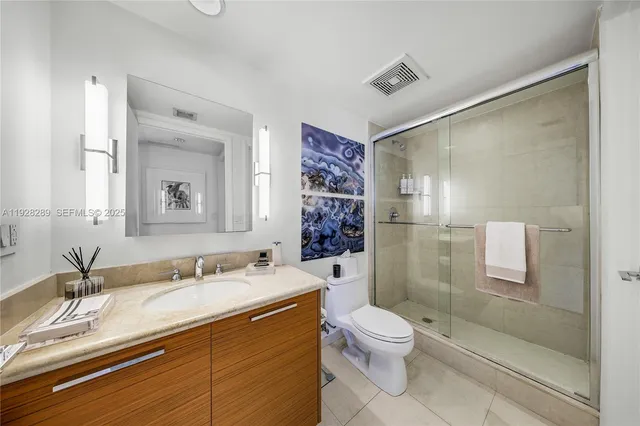 a bathroom with a granite countertop sink toilet and shower