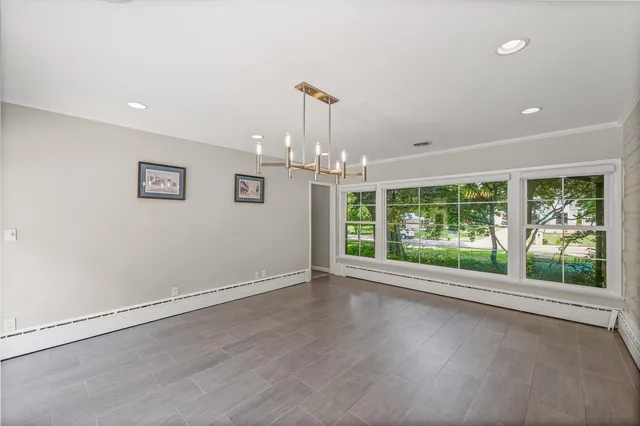 an empty room with wooden floor and outdoor view
