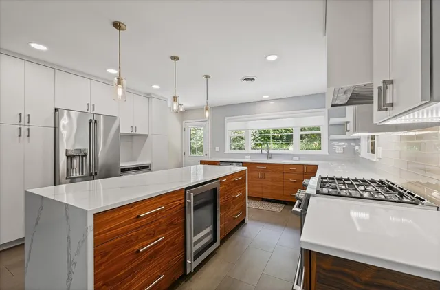 a kitchen with stainless steel appliances granite countertop a sink stove and refrigerator