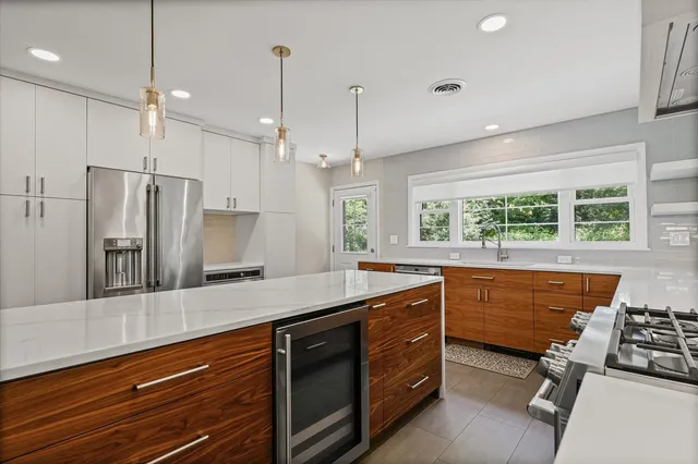 a kitchen with stainless steel appliances granite countertop a sink refrigerator and window