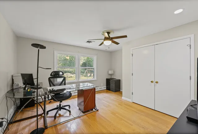 a view of a workspace with furniture and a window