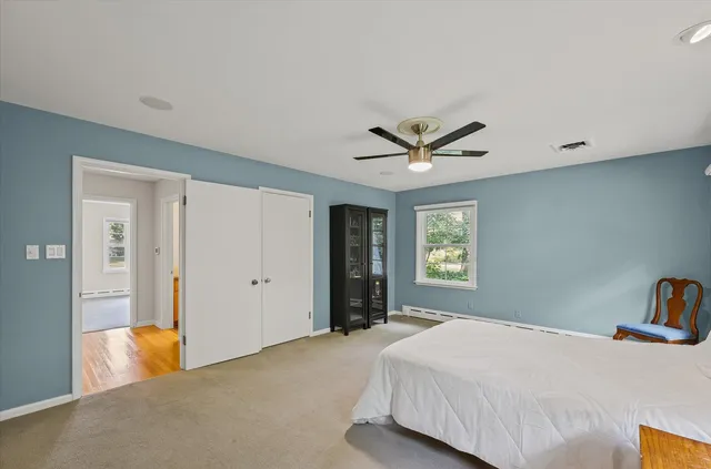 a bedroom with a large bed and a ceiling fan