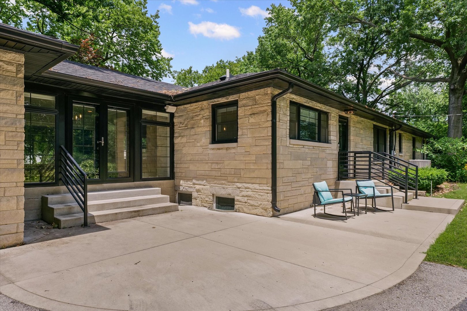 32 Greencroft Drive Champaign, IL 61821 - Photo 33 of 40 a backyard of a house with table and chairs floor to ceiling window and potted plants