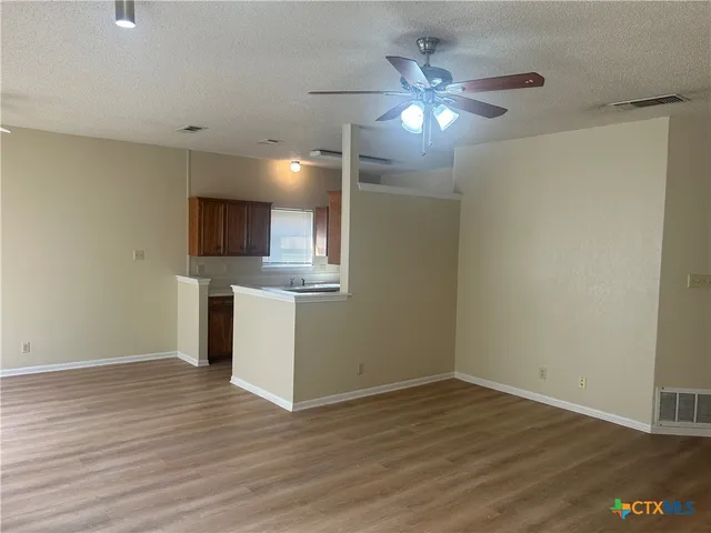 a view of a kitchen with a sink cabinets and wooden floor