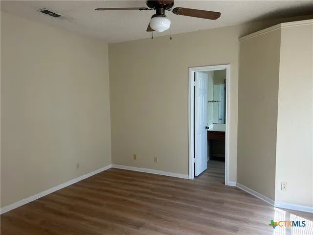 a view of an empty room with wooden floor