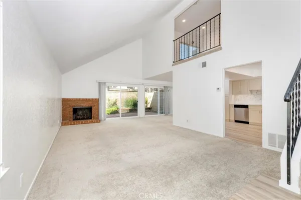 a view of an empty room with a fireplace and a window