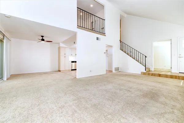 a view of a livingroom with wooden floor and a hallway
