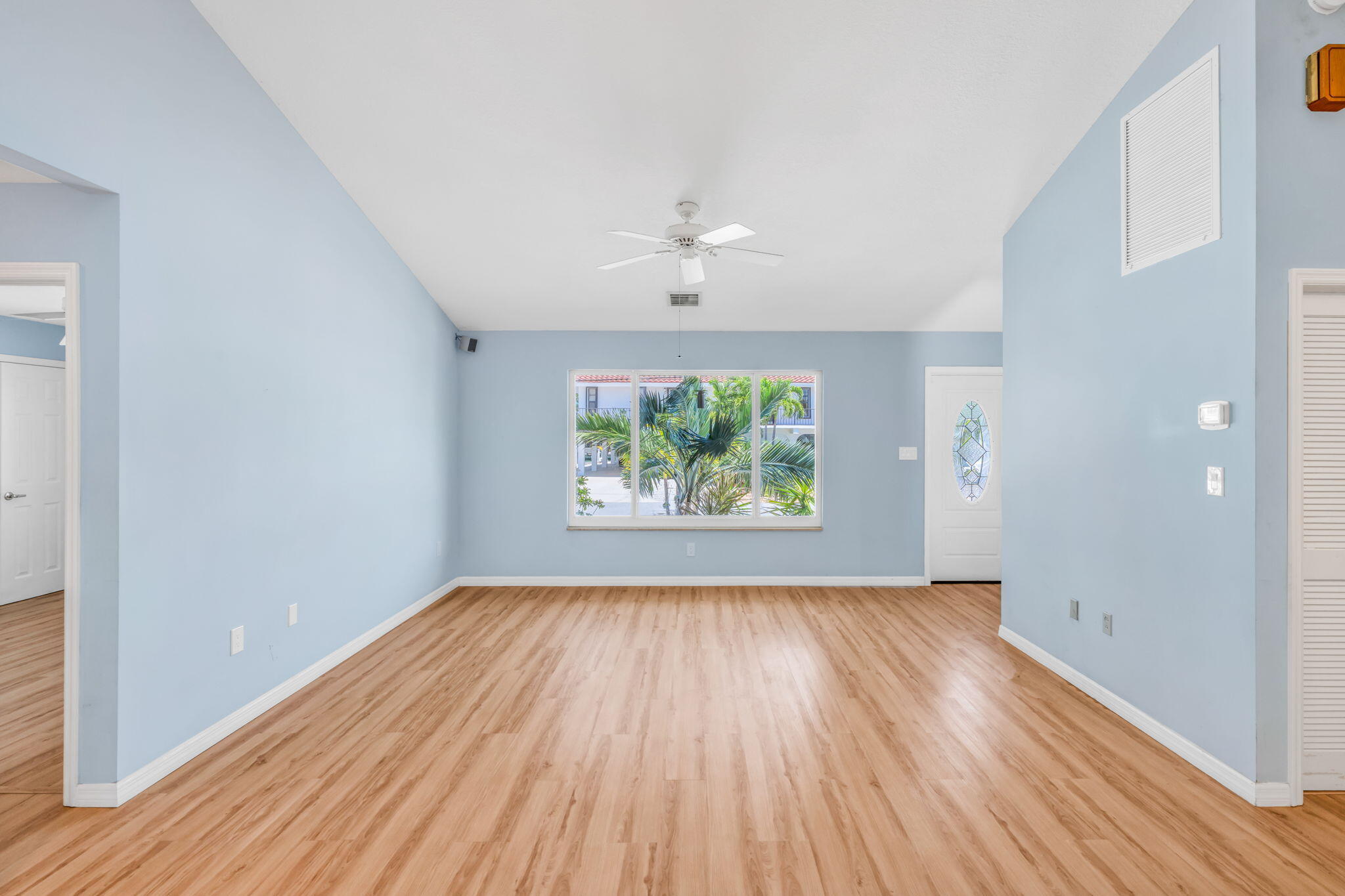501 11th Street Key Colony Beach, FL 33051 - Photo 15 of 52 an empty room with wooden floor chandelier fan and windows