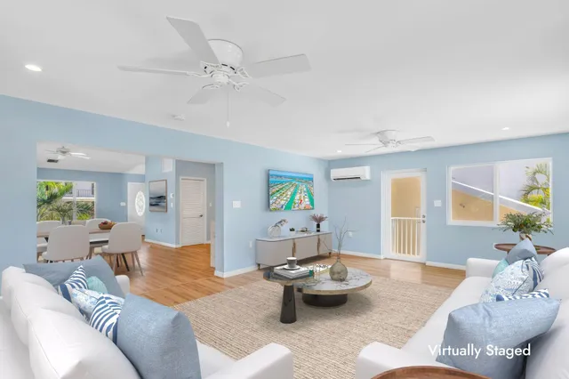a view of a bedroom with wooden floor and a ceiling fan