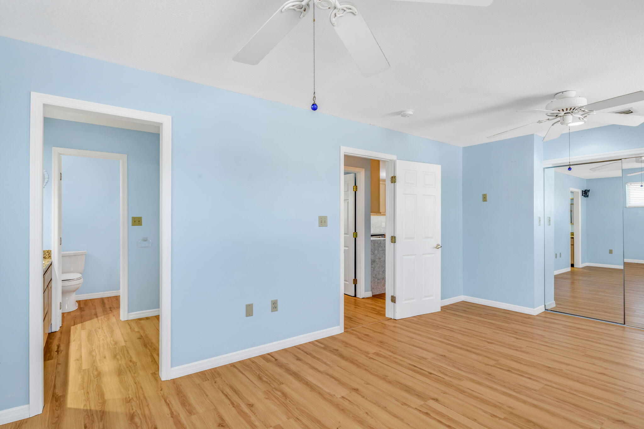 501 11th Street Key Colony Beach, FL 33051 - Photo 30 of 52 a view of a bedroom with wooden floor and a ceiling fan
