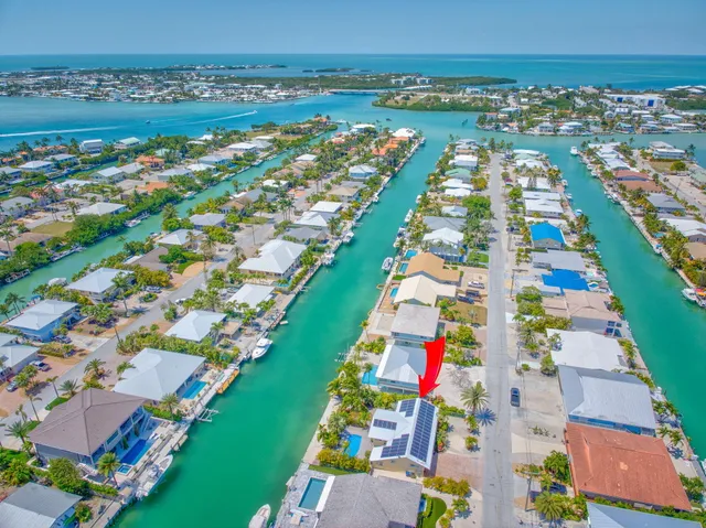 a view of a house with a yard and potted plants
