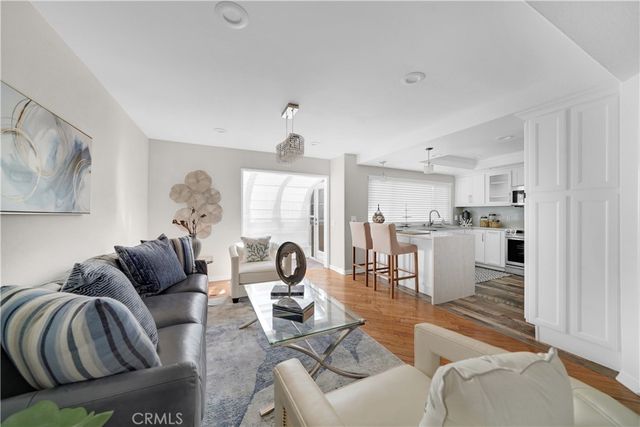 a living room with furniture and a view of kitchen