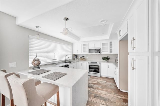 a kitchen that has a lot of cabinets a sink and appliances in it
