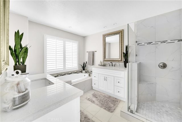 a bathroom with a granite countertop tub sink and mirror