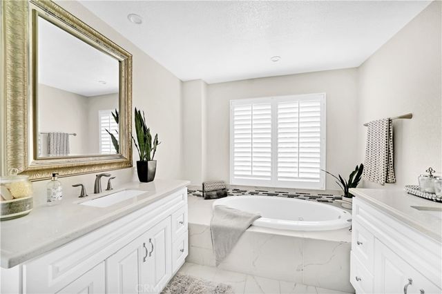 a bathroom with a large tub sink and mirror
