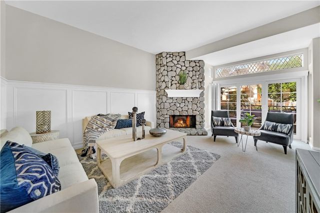 a living room with furniture large window and a fireplace