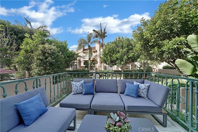 a roof deck with couches and potted plants