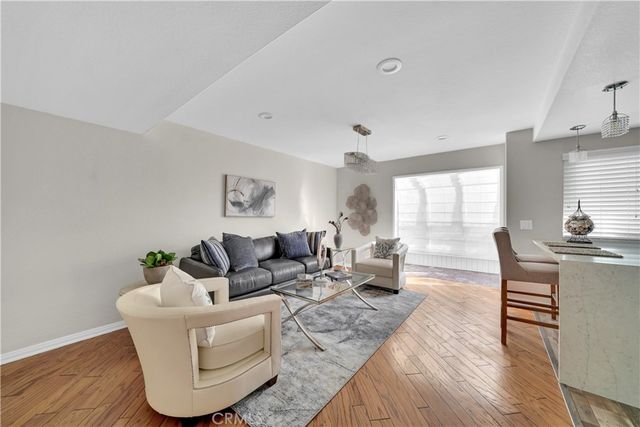 a living room with furniture wooden floor and a large window