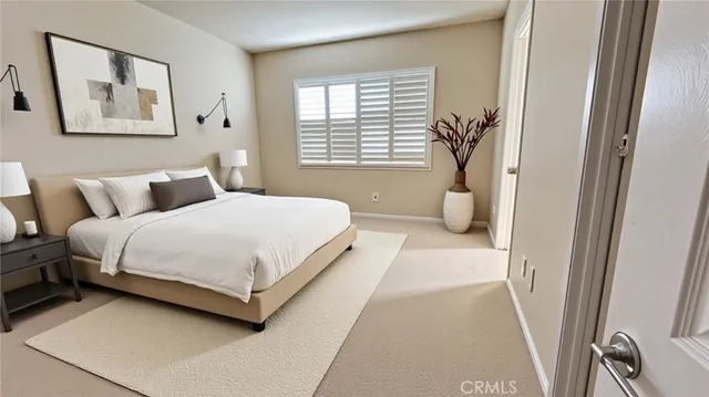 a bedroom with a bed and a large mirror next to a window
