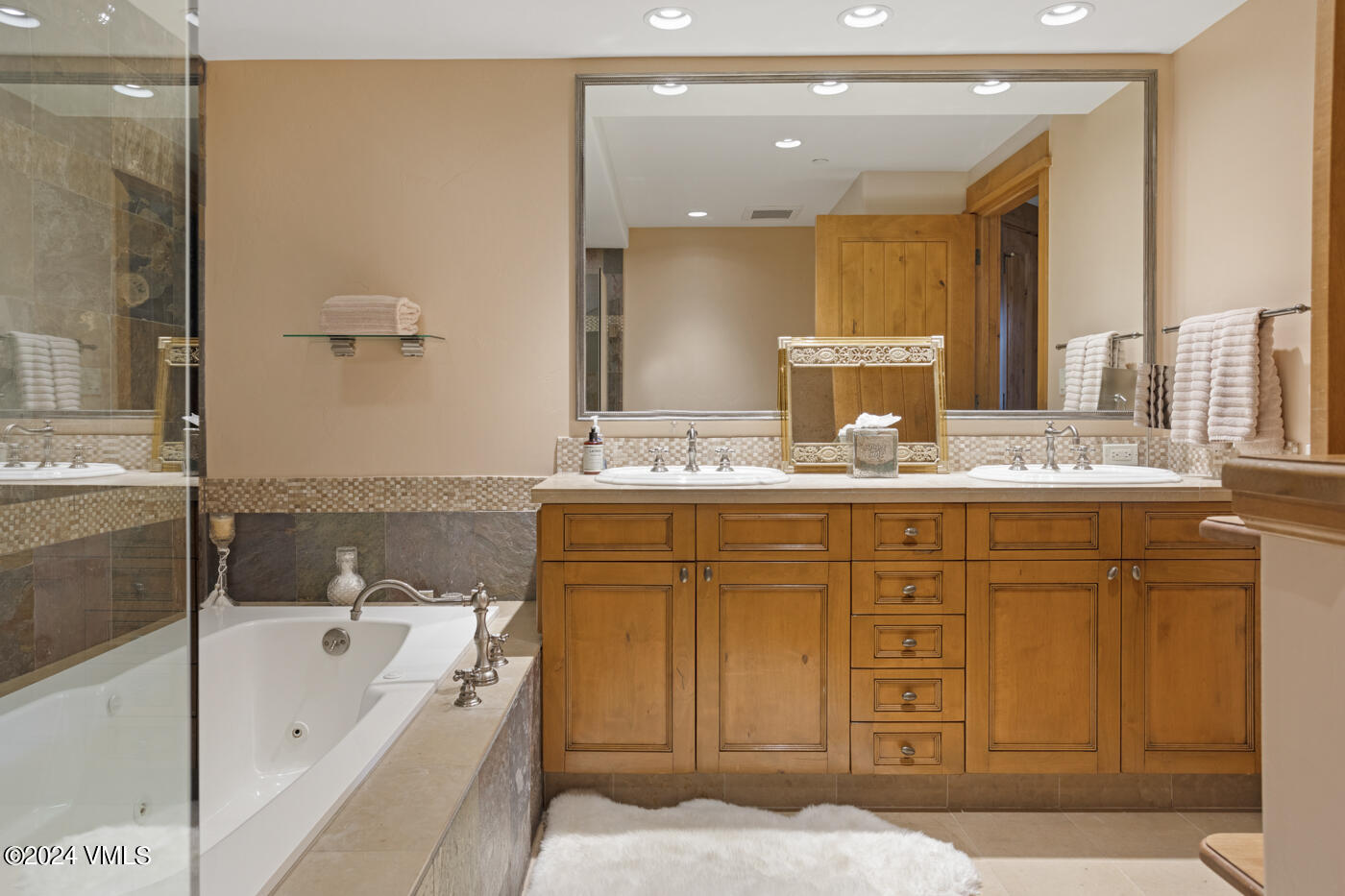 1087 Bachelor Ridge Road, Unit 104 Avon, CO 81620 - Photo 21 of 36 a bathroom with a tub sink and mirror