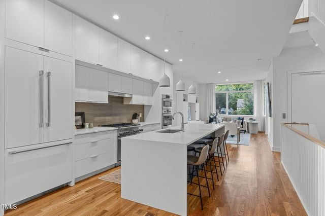 a kitchen with stainless steel appliances a stove a sink a refrigerator and a center island